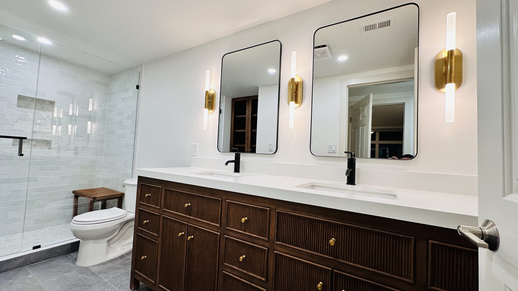 Cherry Creek primary bathroom with dual vanity, brass sconces, and walk-in shower